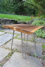 Load image into Gallery viewer, live edge side or accent table, comprising trapezoid shaped black walnut slab and hand-forged steel hairpin legs. Handcrafted for a cool mid century modern look.
