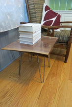 Load image into Gallery viewer, live edge side or accent table, comprising trapezoid shaped black walnut slab and hand-forged steel hairpin legs. Handcrafted for a cool mid century modern look.