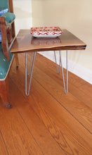 Load image into Gallery viewer, live edge side or accent table, comprising trapezoid shaped black walnut slab and hand-forged steel hairpin legs. Handcrafted for a cool mid century modern look.