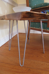 live edge side or accent table, comprising trapezoid shaped black walnut slab and hand-forged steel hairpin legs. Handcrafted for a cool mid century modern look.