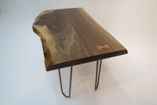 Load image into Gallery viewer,  live edge side or accent table comprised of black walnut slab with hand-forged hairpin legs for a cool mid-century modern look. Slab is hand finished and accented with a single cherry bowtie inlay