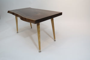 live edge, danish modern-style side or accent table in black walnut slab. Table has repurposed Paul McCobb-style tapered legs danish for a cool mid century modern look