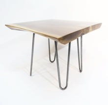 Load image into Gallery viewer, live edge side or accent table, comprising trapezoid shaped black walnut slab and hand-forged steel hairpin legs. Handcrafted for a cool mid century modern look.